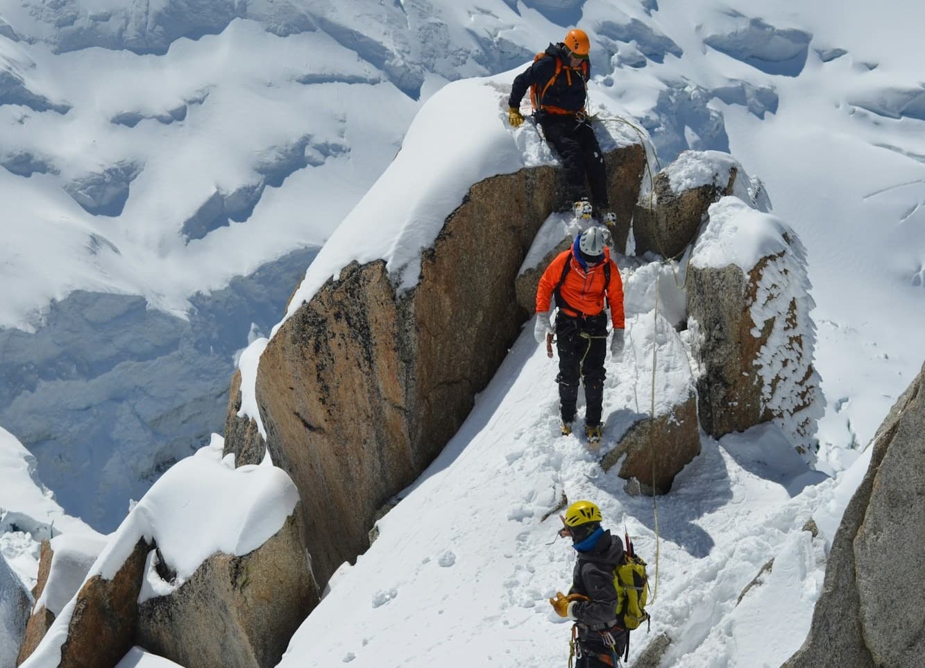 Trekkers climbing down a mountain with sherpas