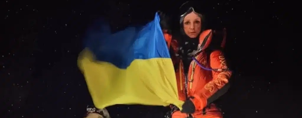 Russian Climber holding Ukranian Flag in Everest.