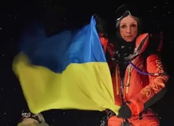 Russian Climber holding Ukranian Flag in Everest.