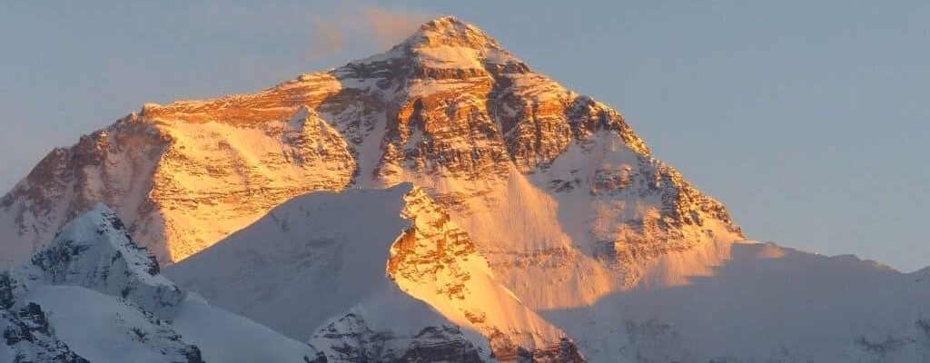 A golden sunrise illuminating the snow-capped peak of Mount Everest