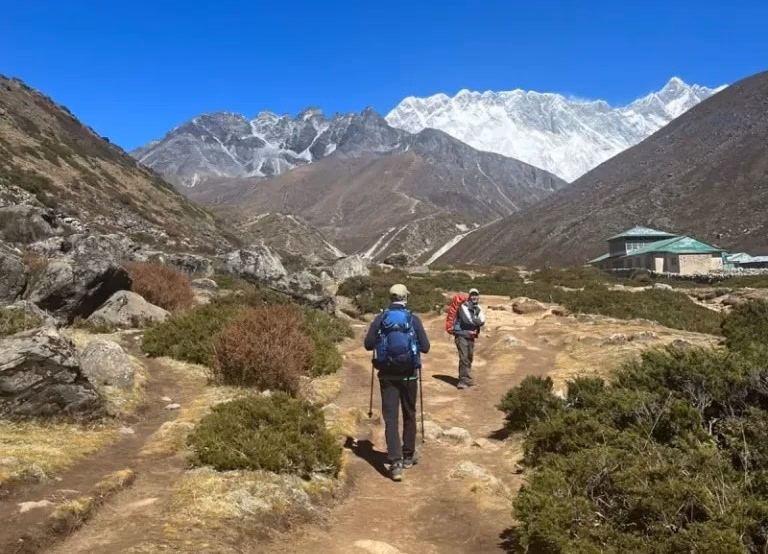A trekker using trekking poles to walk on the EBC route