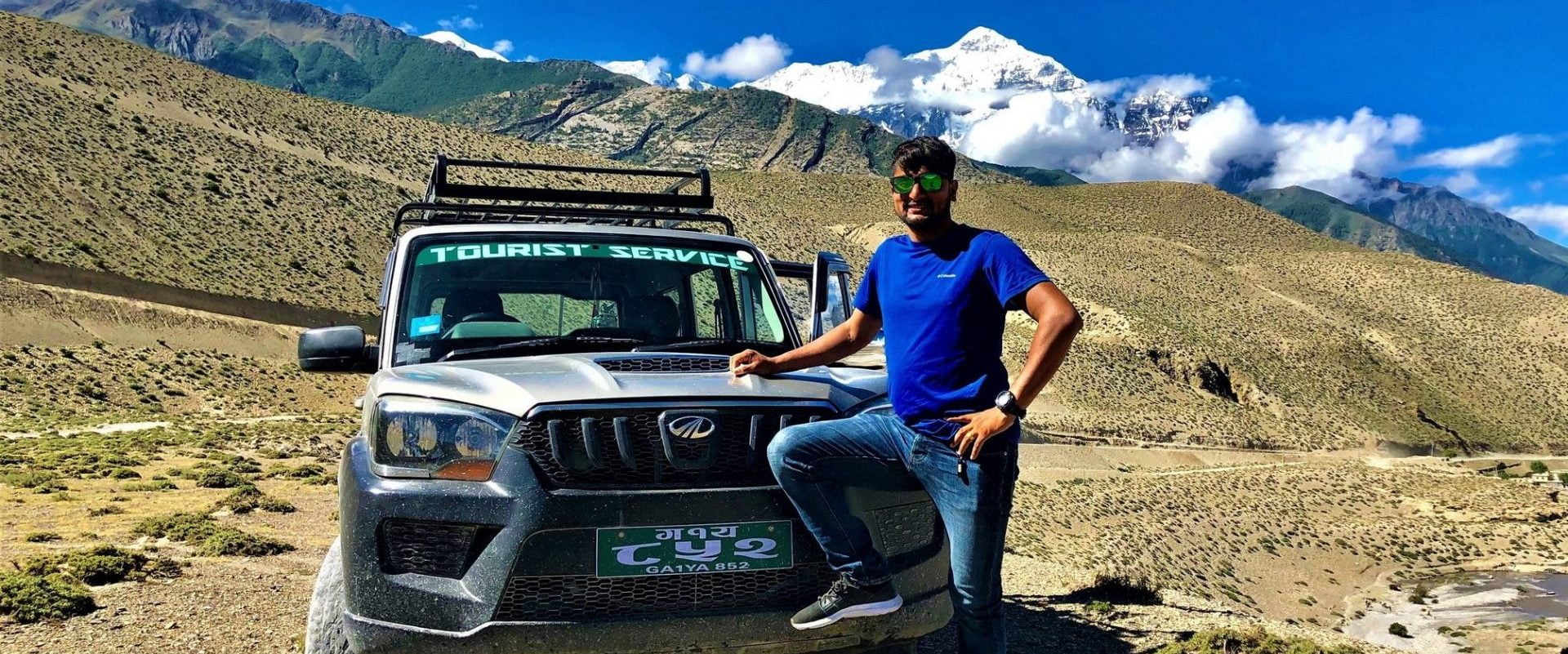 A man standing in front of a jeep that goes to Upper Mustang (Upper Mustang Jeep Tour)