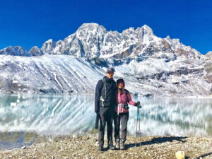 two trekkers with a trekking pole posing for a photo in Gokyo lake
