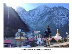 a girl posing for aa photograpgh at tengboche during mount everest base camp trek