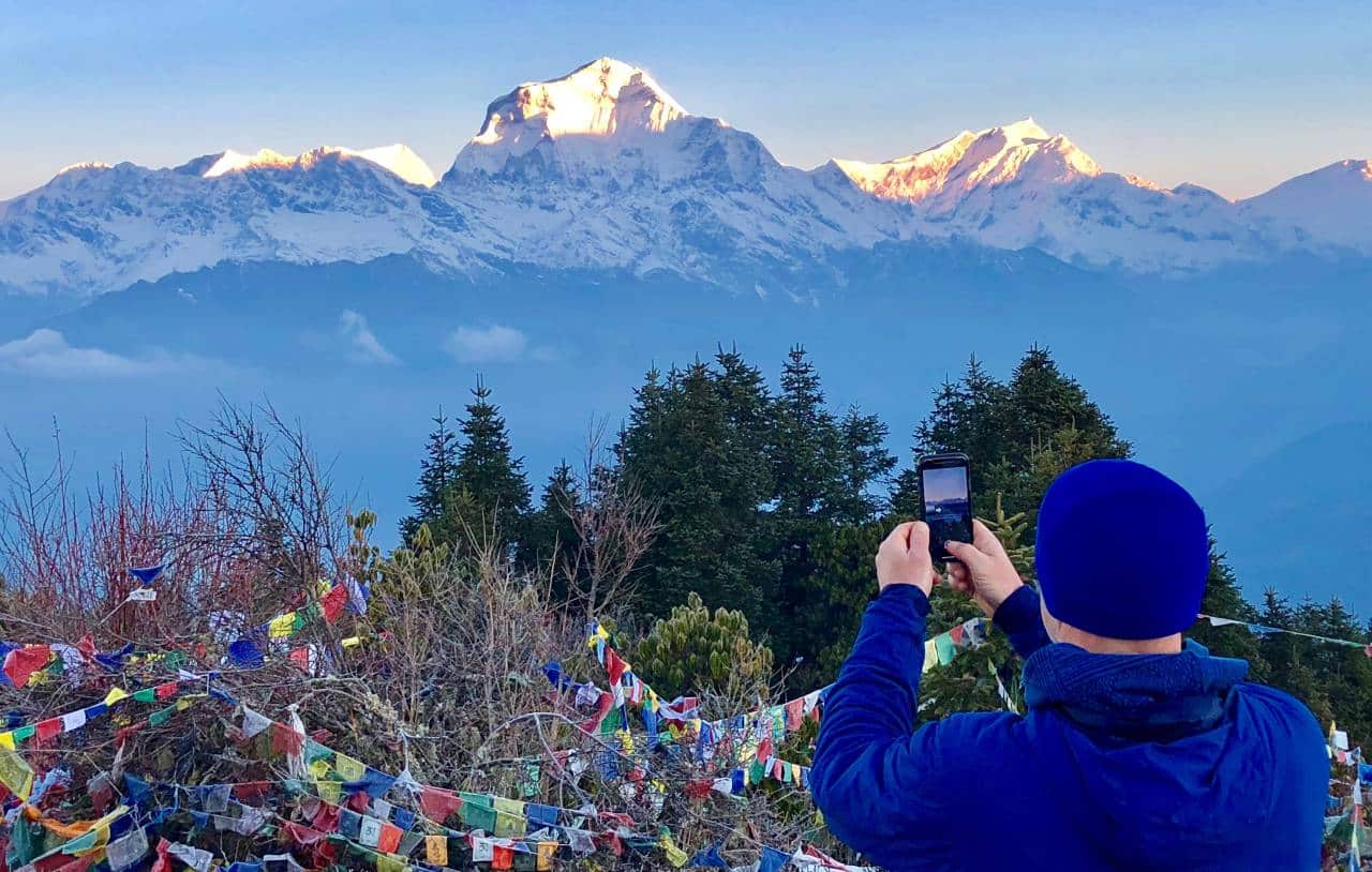 A visitor taking photo of the Himalayas from Poonhill