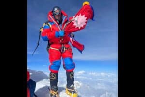 Sanu Sherpa holding flag of Nepal after climbing all the  8000'er peaks twice